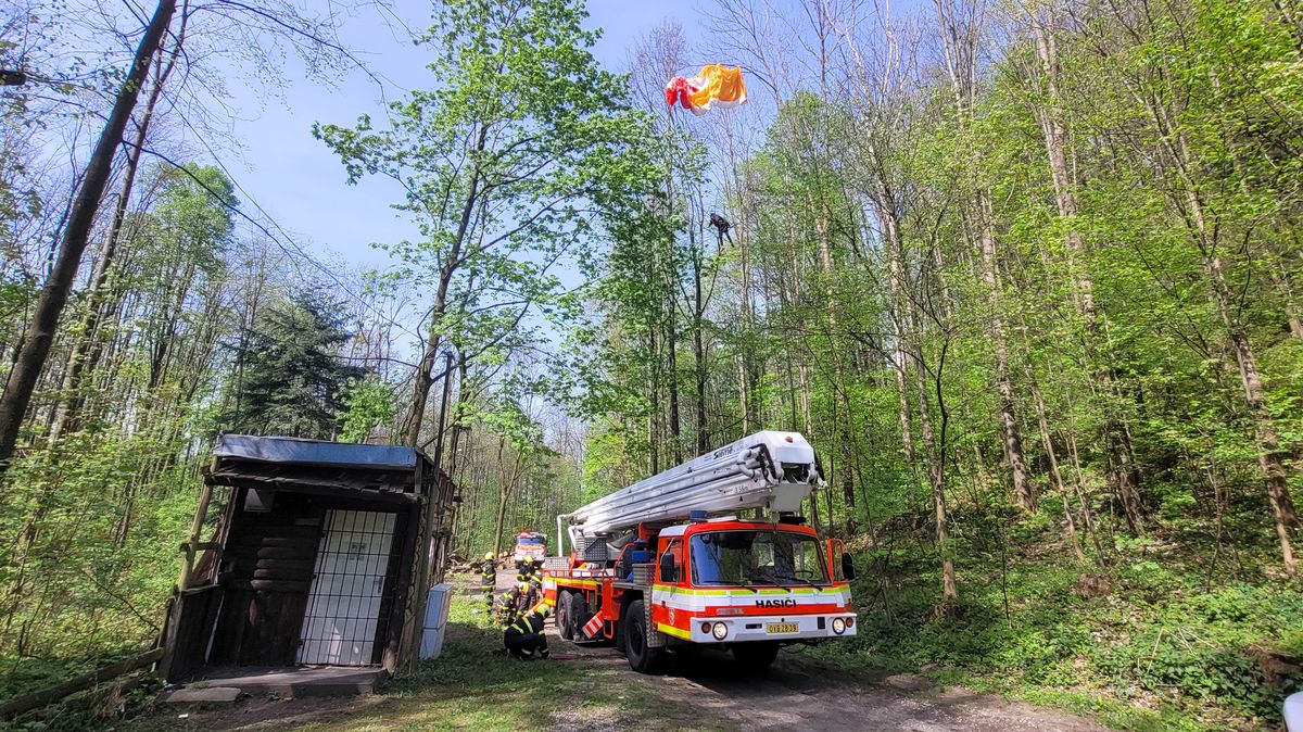 Paraglidista na stromě zaměstnal několik hasičů, museli přivézt i plošinu